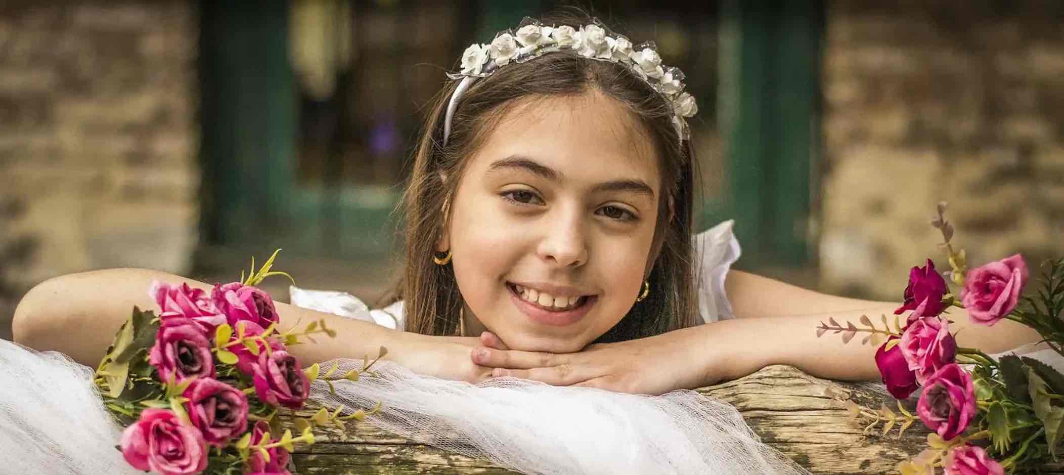 Mädchen ist festlich gekleidet und blickt lächelnd in die Kamera